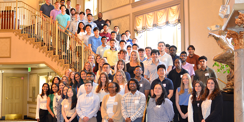 Interns posing on a staircase and smiling